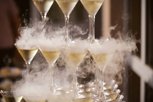 champagne in glasses standing on the table with a glass goes the smoke