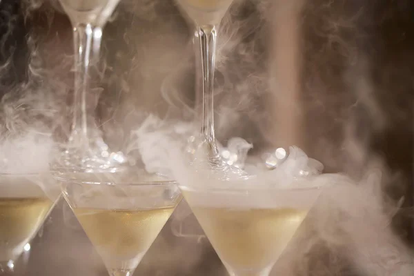 champagne in glasses standing on the table with a glass goes the smoke