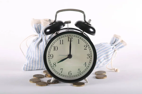 clock alarm clock and money lie on white background