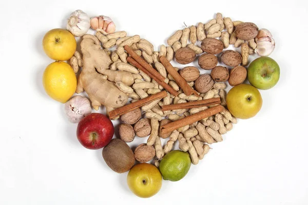 fruits and nuts lie on a white background in the form of a heart