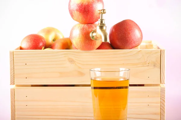 the tap in the Apple and a glass of Apple juice is on the table