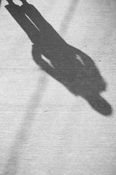 the shadow of a man on the pavement background image