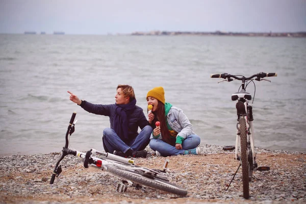 two girls walk ride a bike and eat ice cream