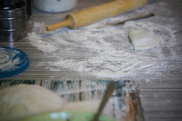 Homemade chebureks are cooked on the table with flour