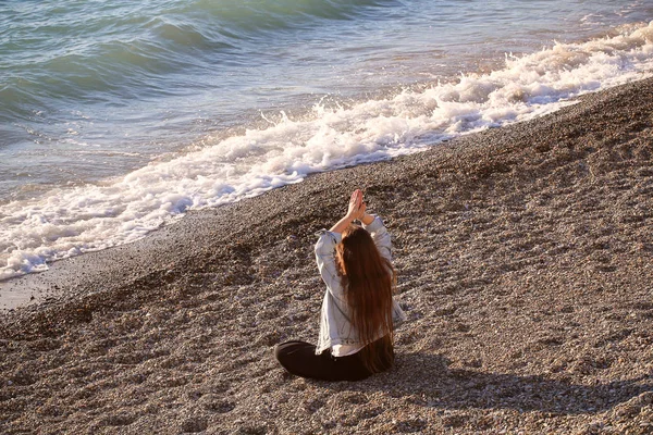 girl sitting in nature in a yoga pose and resting