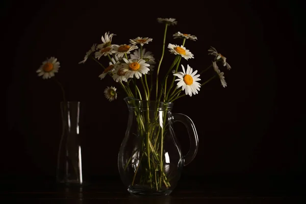 bouquet of daisies is in a vase on a black background