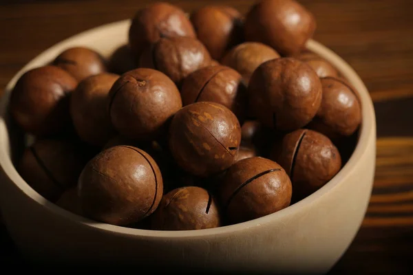 macadamia nuts lie on a black background