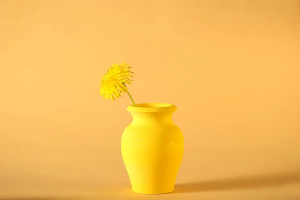 a yellow wooden vase stands on a yellow background