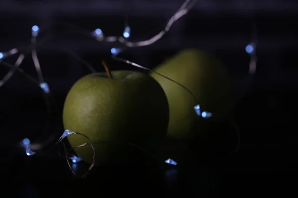 green apples on a black background with lights