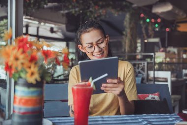 Asyalı kadınlar ipad ile mutlu bir mood.focus yüzündeki bak