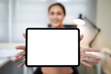 Bir kadın elinde beyaz ekranlı bir tablet tutuyor. Gülümsüyor ve mutlu.