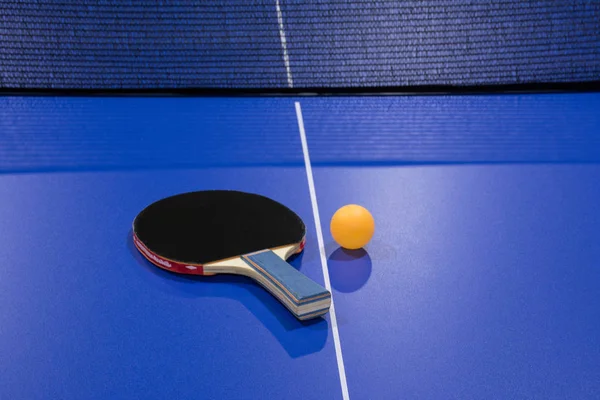 Tennis racket with a ball on the tennis table