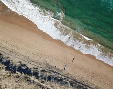 Deniz dalgaları ve insanlar Yürüyen gölgeler. Üstten görünüm havadan fotoğraf doğa manzara turkuaz su Wanda Plajı ile drone Cronulla kış günü uçan üzerinden. Seyahat tatil kavramı.