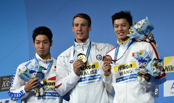 Будапешт, Венгрия - 27 июля 2017 г. ВАН ШУН (Китай), ХАГИНО КОСУКЕ (Япония) и победитель КАЛИШ ЧЕЙЗ (США) на дистанции 200 м у мужчин в личном первенстве Мэдли. Чемпионат мира по плаванию
.