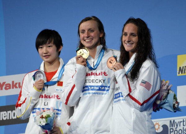 Будапешт, Венгрия - 29 июля 2017 г. ЛИ Бинцзе (Китай), победительница LEDECKY Katie (США) и FEITH Leah (США) на церемонии Victory of the Women 's Band Fly. Чемпионат мира по плаванию
.