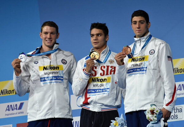 Будапешт, Венгрия - 28 июля 2017 г. Пибли Джейкоб (США), Мерфи Райан (США) и победитель Евгений Рылов (Россия) на дистанции 200 м брассом. Чемпионат мира по плаванию
.