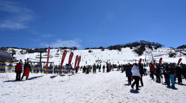 Perisher, Avustralya - 30 Eylül 2018. Ski resort teleferik, kayakçılar ve dağ manzaralı panorama. Hobi kayakçı renkli giysiler içinde onlarca aktif kış tatillerini tadını çıkarıyor.