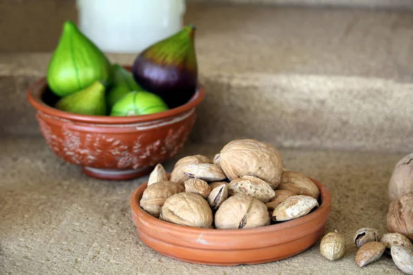 Küçük seramik kase ceviz ve badem, incir arka planda bir kase ile