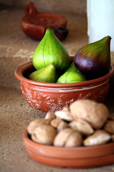 İncir, ceviz ve badem içinde odak ön plan dışında küçük bir seramik kase desenli kase