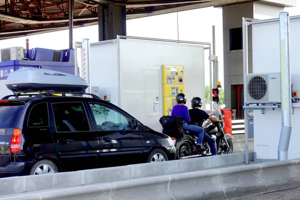 Languedoc-Roussillon, Fransa - 27 Temmuz 2018: Otomatik seyahat ücretini ödeyen otoyol kapısı veya Peage 'de sürücü ve yolcu taşıyan bir motosiklet