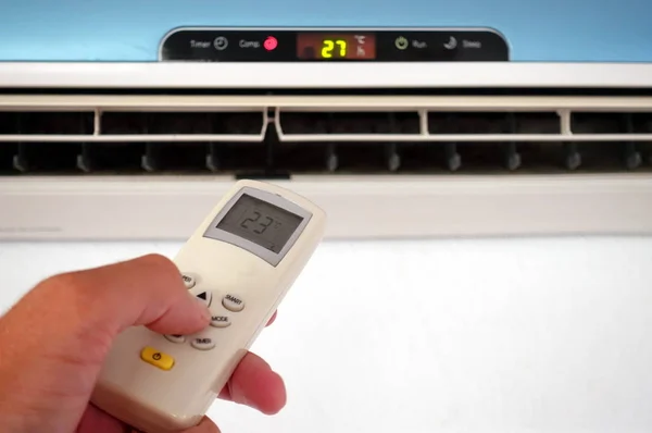 Birisi uzaktan kumandayla yerel klima ya da klima ayarlarını değiştiriyor - uzaktan kumandaya odaklan
