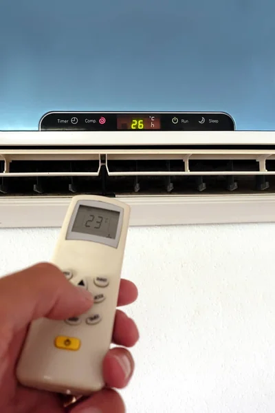 Birisi klima veya klima ayarlarını uzaktan kumandayla değiştiriyor - duvar ünitesine odaklan