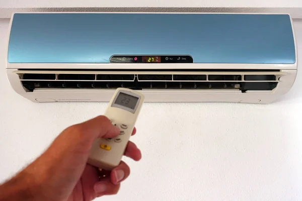 Birisi klima veya klima ayarlarını uzaktan kumandayla değiştiriyor - duvar ünitesine odaklan