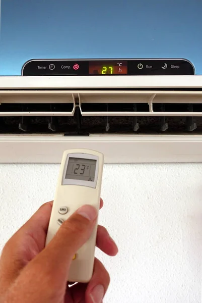 Birisi klima veya klima ayarlarını uzaktan kumandayla değiştiriyor - duvar ünitesine odaklan
