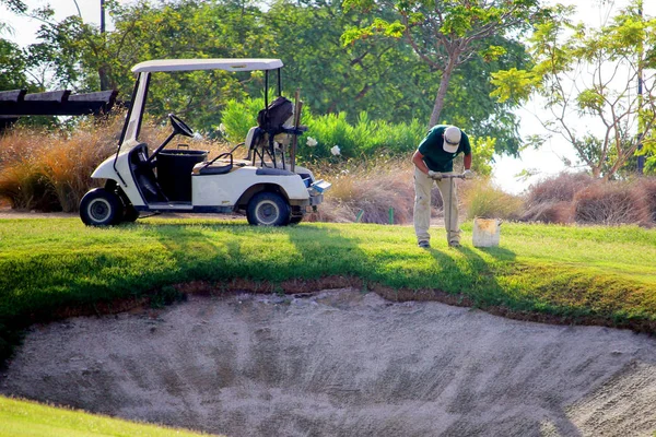 Sucina, İspanya - 08 Ağustos 2018: Golf sahasında bir bahçıvan, elinde bir kehanetle bir sığınağın yanındaki toprak örneklerini topluyor..