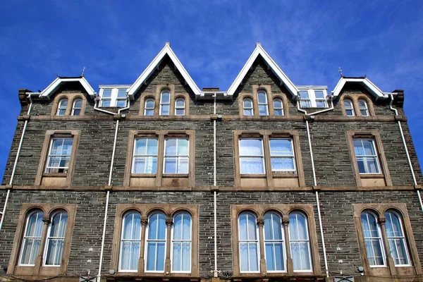 Geleneksel kuşak pencereleri ve taş mulyonları olan klasik taş bina