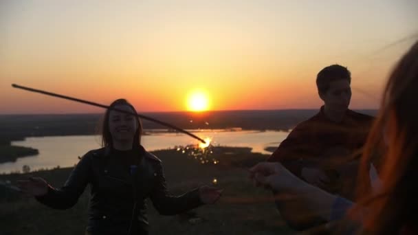 Szczęśliwy przyjaciół spotykać się z ognie i grać na gitarze w summer zachód słońca — Wideo stockowe