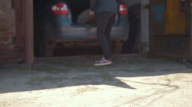 Genç adam tekerlekli araba gövdesinden atar.