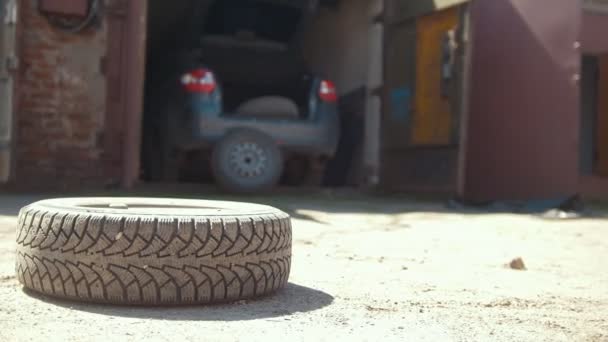 Ruedas de coche rodando en el suelo delante del garaje del coche — Vídeos de Stock