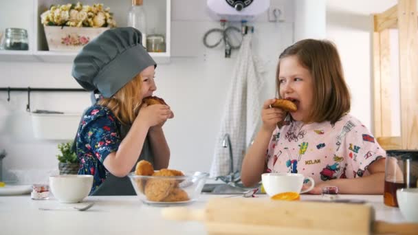 Two girls eats cookies with jam prepared with their own hands — Stock Video