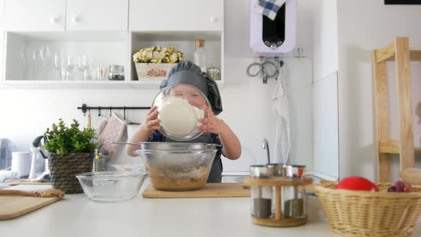 Předškolní dívky baker sifts mouky do mísy na vaření sušenky