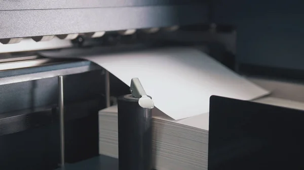 Печатный станок принимает листовой лист бумаги в действие на полиграфической линии — стоковое фото