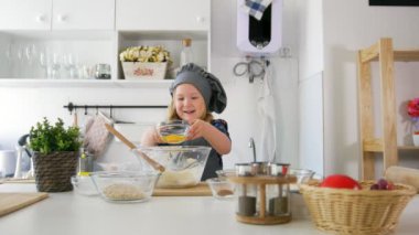 Küçük kız baker tereyağı bisküvi yemek pişirmek için pasta hamur koyar