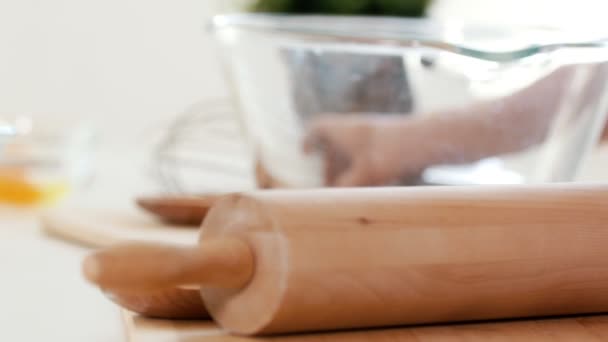 Rolling pin devant un grand bol en verre main d'enfant tenant un fouet — Video