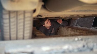 Ayrıntılar tepsi altından gevşeterek bir araba altında genç adam