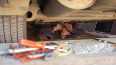 Önünde bir araba altında araçlar kümesi ayrıntıları onarır