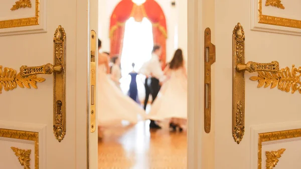 Mujeres jóvenes y hombres en atractivos vestidos vintage en el salón de baile — Foto de Stock