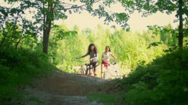 Ormanda bir bisiklet, bisikletçi iki kız arkadaşım iyi eğlenceler iletişim ve takas üzerinden yolunu tırmanmak