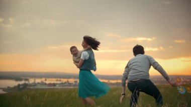 Anne Çocuk onu içinde silah, baba atlar ve çalış, tutar turuncu günbatımı