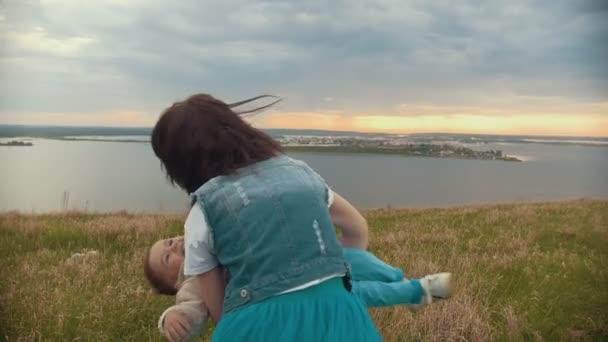 Das Mädchen mit dem Sohn, der das Feld umkreist, ein bewölkter Sommertag — Stockvideo