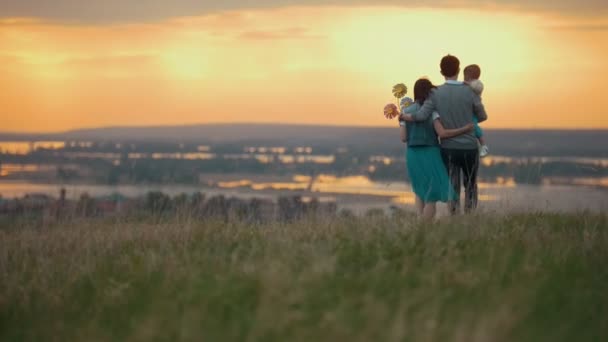 Familj på 3 personer vilar i naturen, Mamma pappa och son gå och mysa, orange solnedgång — Stockvideo