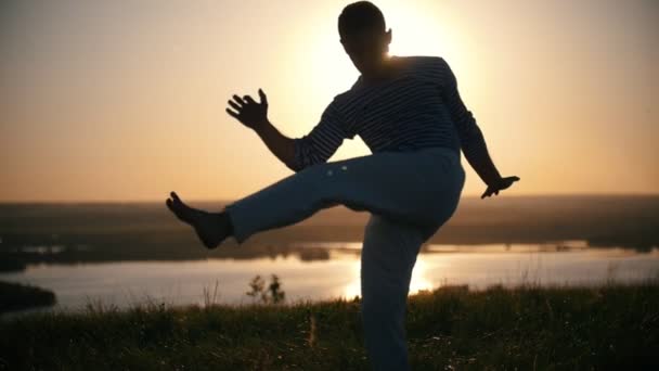 Il combattente fa una postazione sullo sfondo del sole al tramonto, al rallentatore — Video Stock