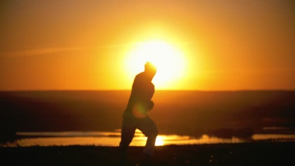 Acrobat faz roda para trás, pôr do sol, câmera lenta — Vídeo de Stock