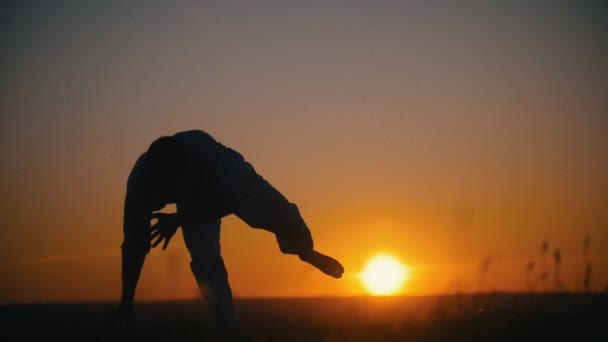 Fighter utför akrobatiska stunts, utomhusträning, sommar solnedgång, slow motion — Stockvideo