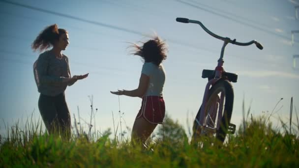 Duas meninas se aquecem, saltam antes de um passeio de bicicleta, dia ensolarado — Vídeo de Stock