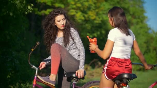 Отдых на велосипеде, две женщины-велосипедистки пить воду и говорить, солнечный летний день — стоковое видео